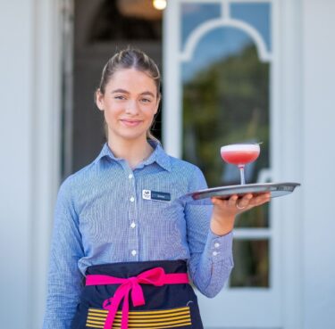 A waitress serves a cocktail